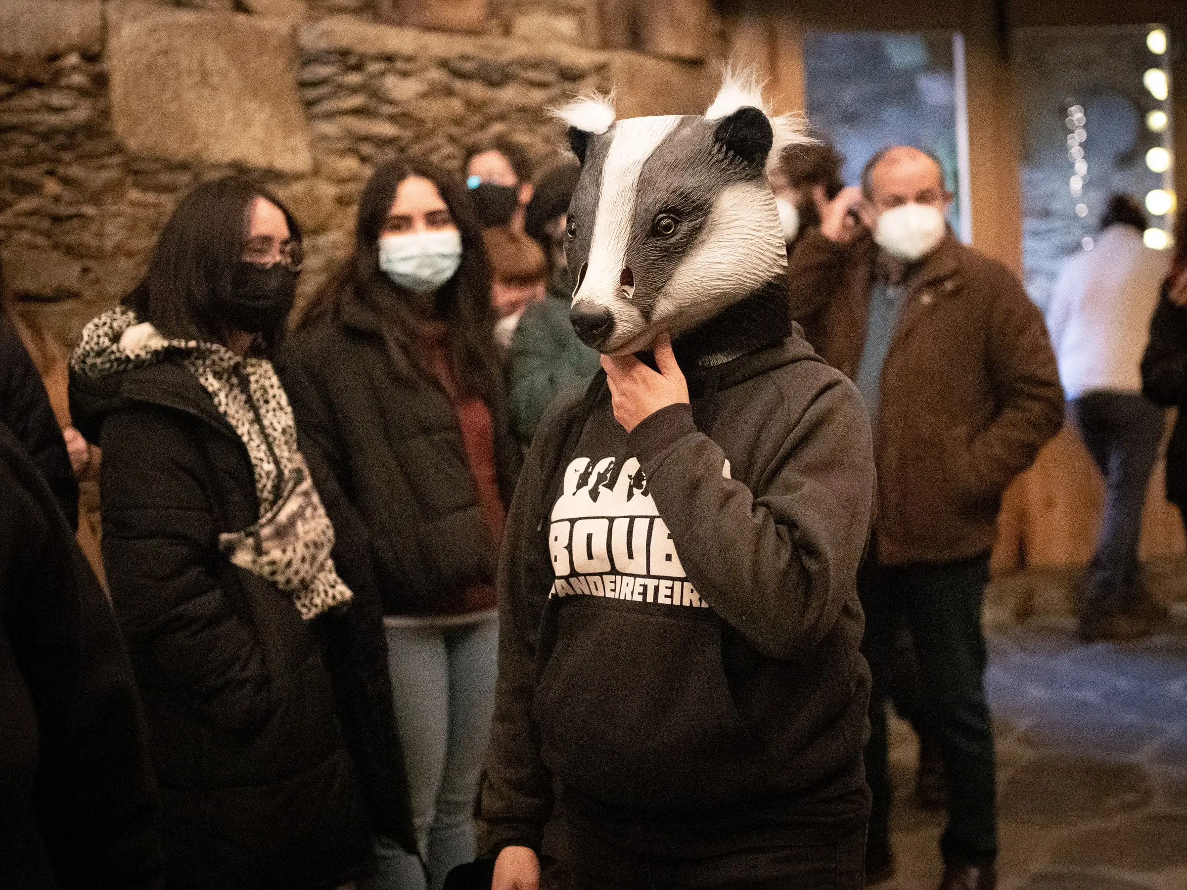 Unha Bouba con máscara de teixugo entre o público