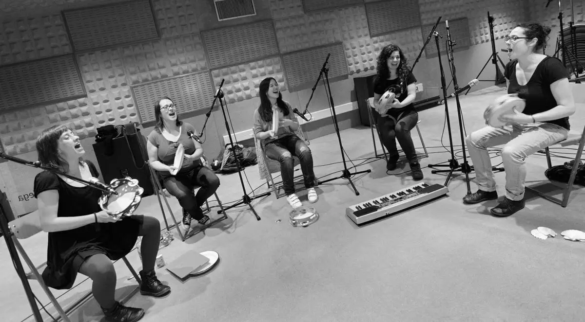 As cinco gravan sentadas en roda nun estudio, en branco e negro
