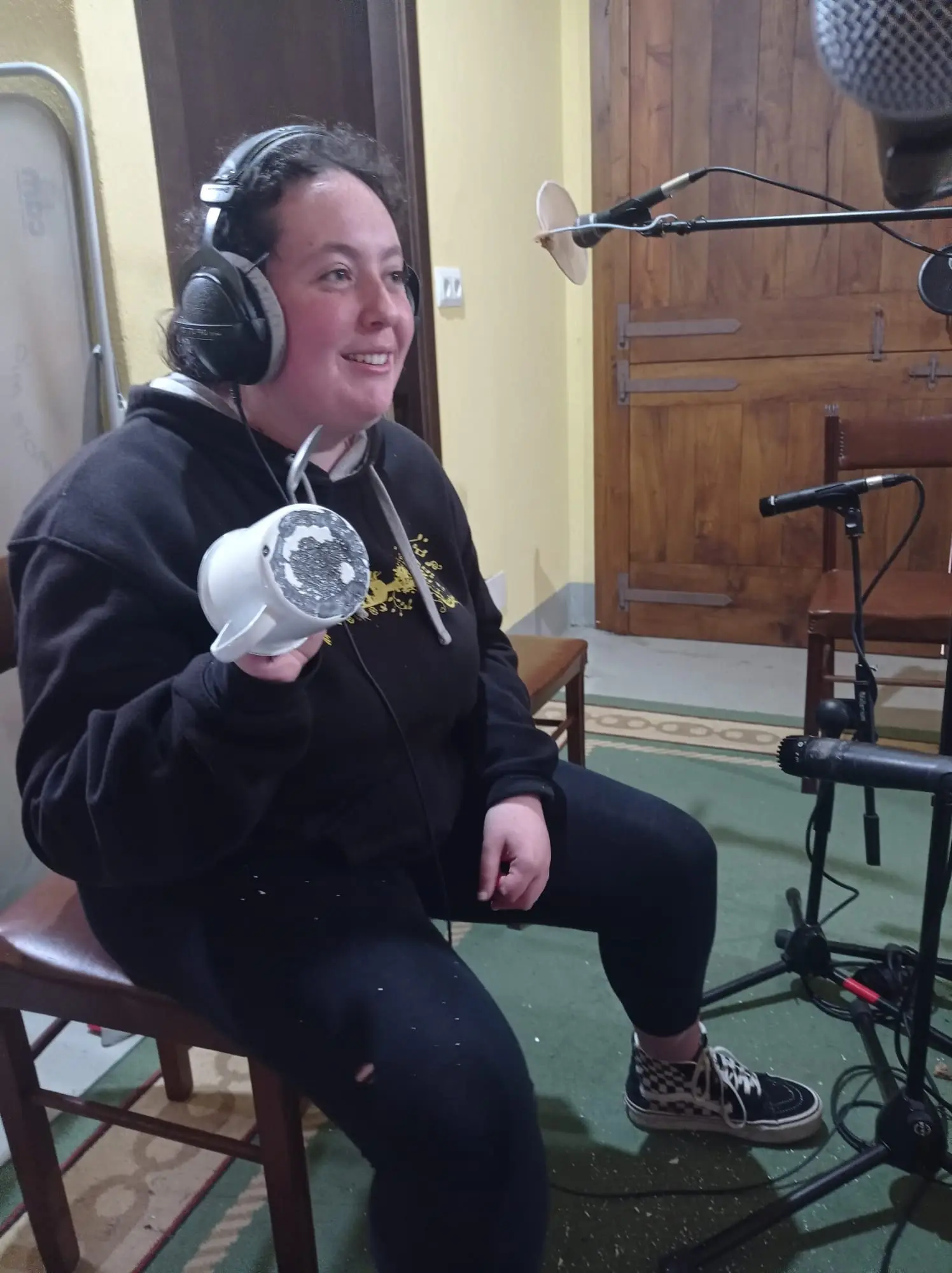 Unha Bouba sentada, con auriculares, diante do micrófono