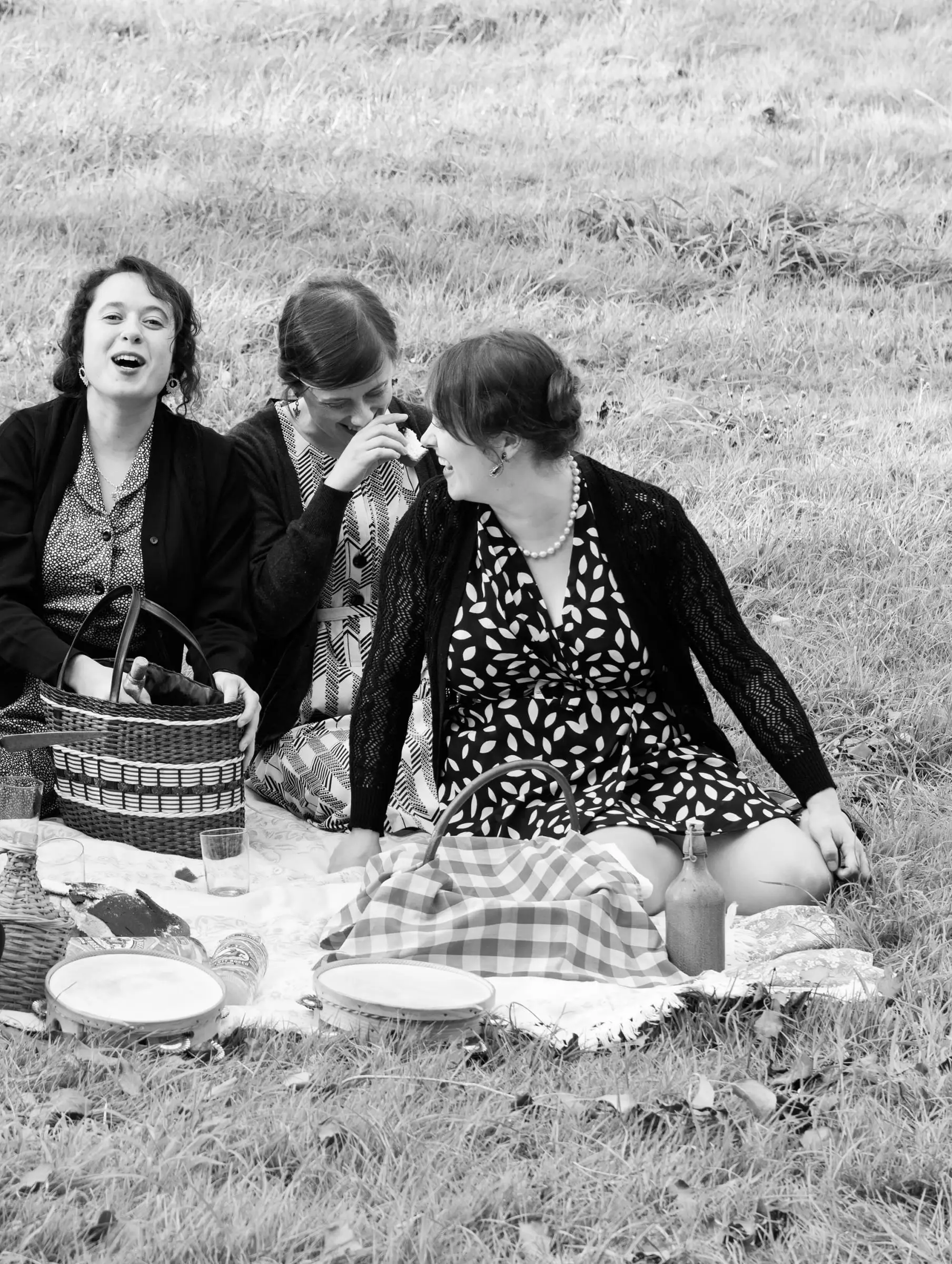 Tres mulleres de merenda nun prado, en branco e negro