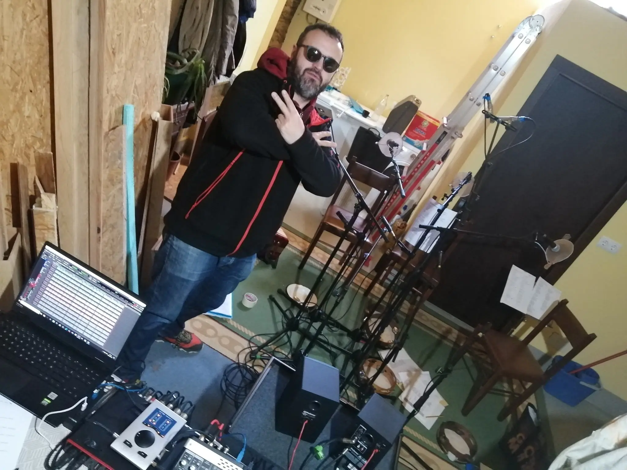 Un técnico de pé xunto á mesa de son e o ordenador