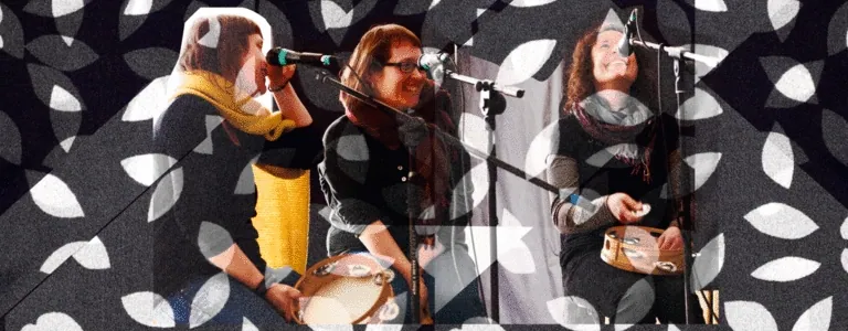 Tres Bouba cantan e rin ao micrófono, coas pandeiretas na man, sobre un estampado de follas.